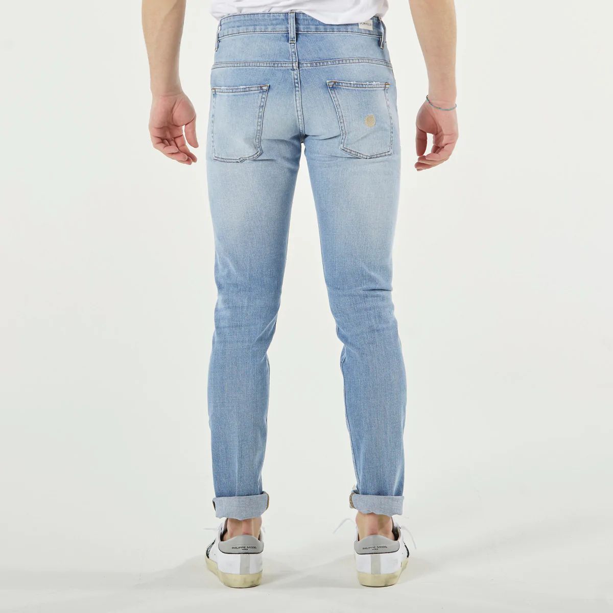 Enfilez le jean slim bleu clair plus ample